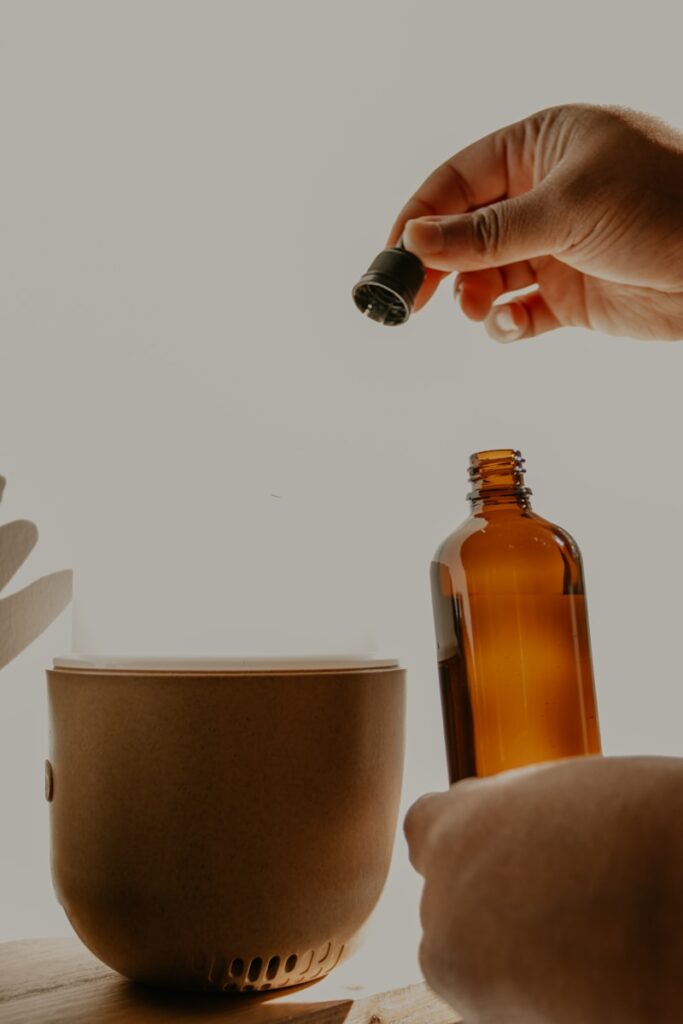 person holding brown glass bottle